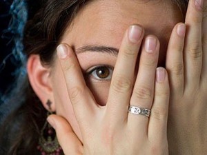 Shy woman - peeking thru fingers