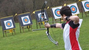 youth firing arrow at target